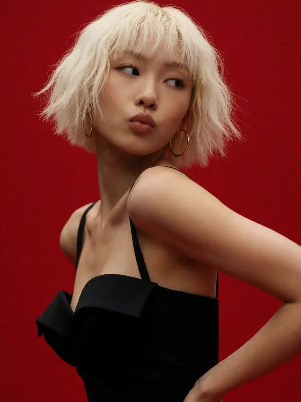 Krea 2 example: high-fashion editorial portrait of a young East Asian woman, short choppy platinum blonde bob with heavy bangs, looking