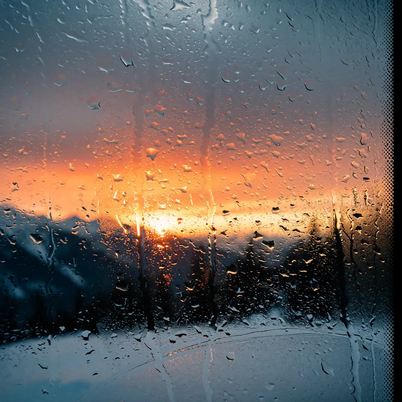 Krea 2 example: A sunset over snowy mountains. rainy window style